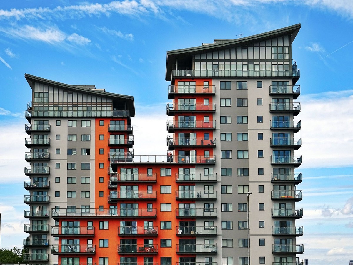 Modern apartment towers with orange and grey facade panels and glass balconies