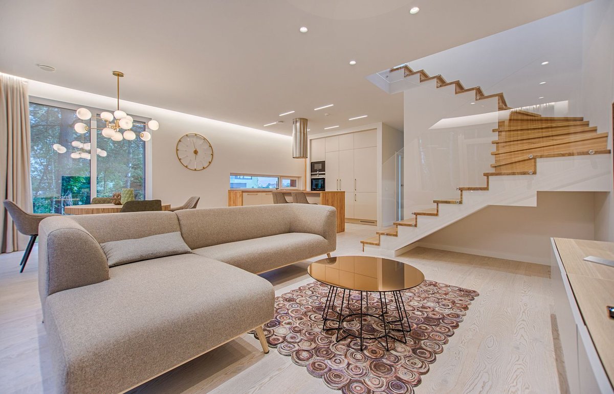Modern living room with sofa and lounge seating near a bright window